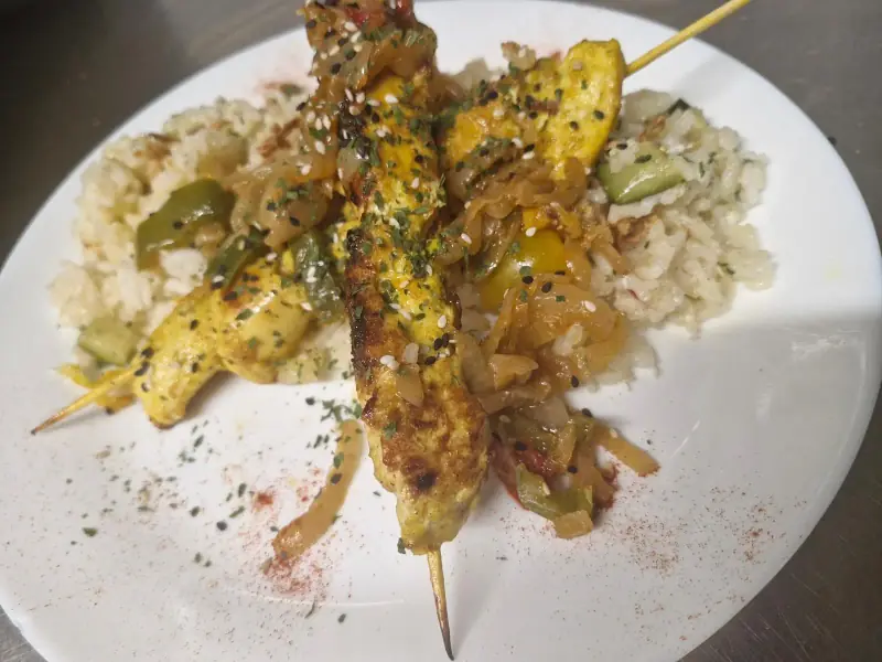 Brochettes de poulet aux épices sur riz et légumes