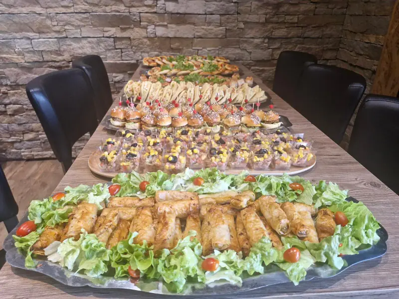 Buffet apéritif sur une longue table : briouates, mini-burgers, verrines et mini-pizzas